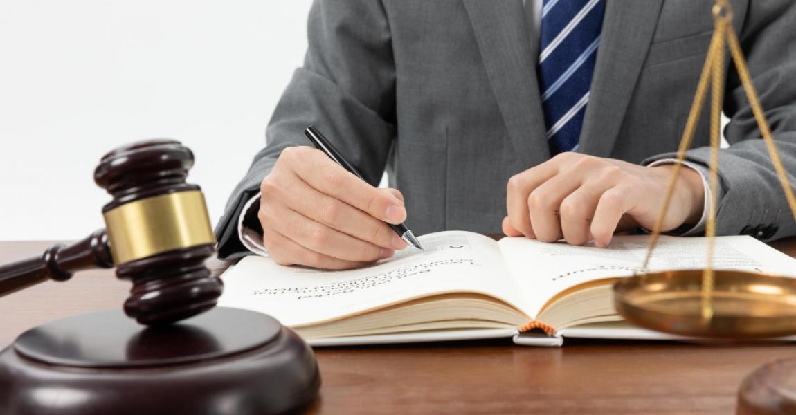 closeup-shot-person-writing-book-with-gavel-table.jpg