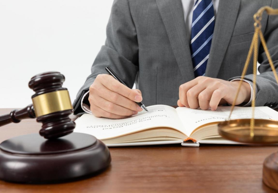 closeup-shot-person-writing-book-with-gavel-table.jpg